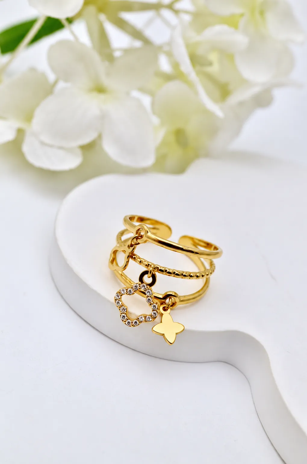 Gouden ring met klaverbedels en steentjes