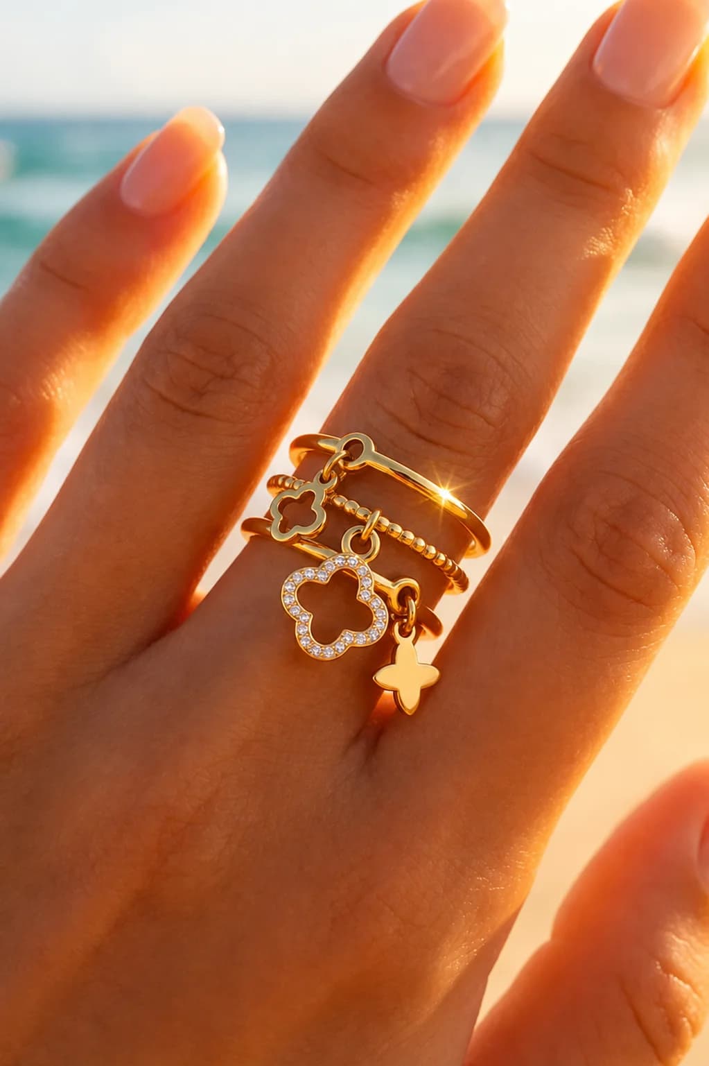 Gouden ring met klaverbedels en steentjes