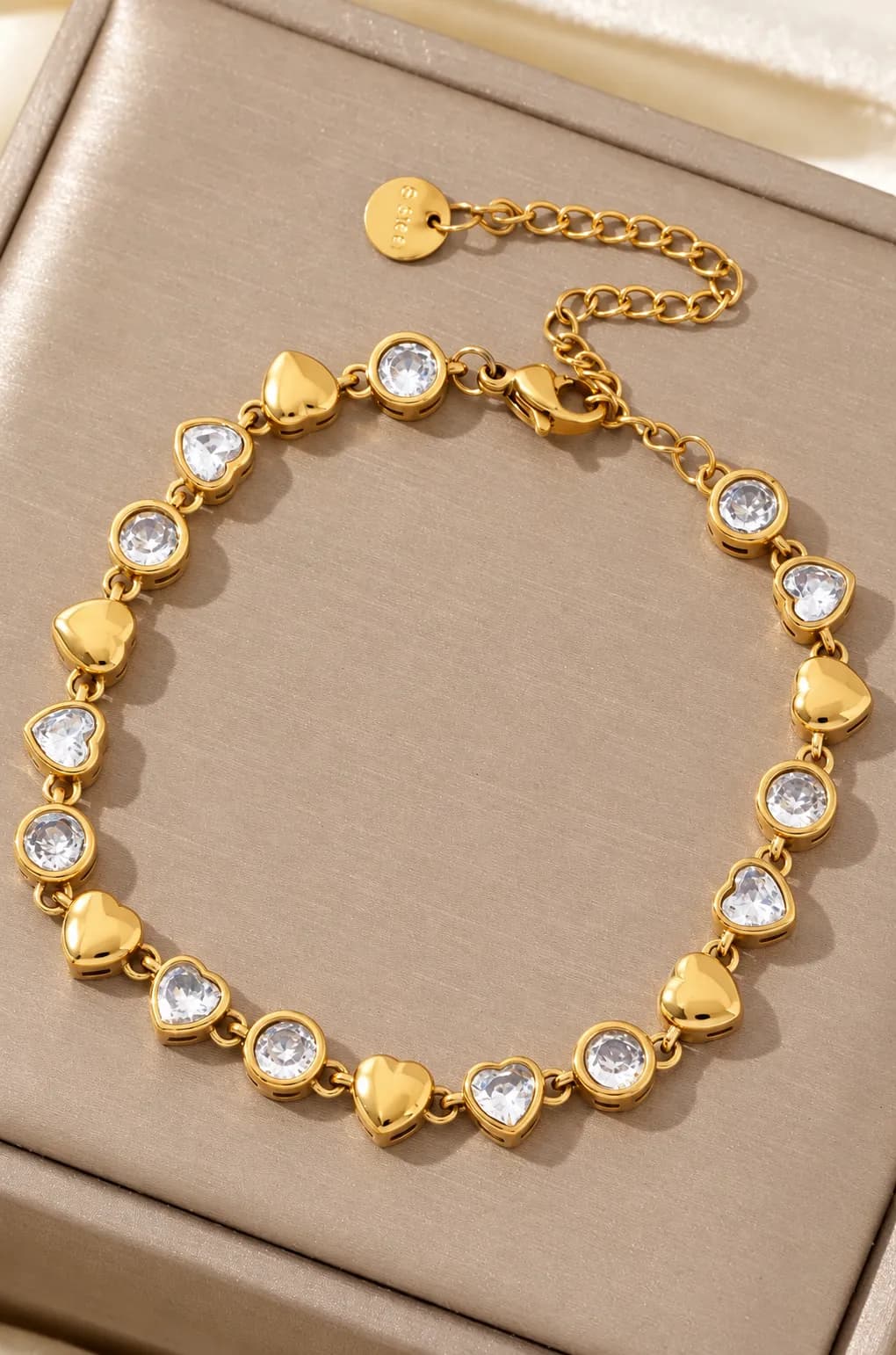 Gouden armband met hartjes en witte steentjes