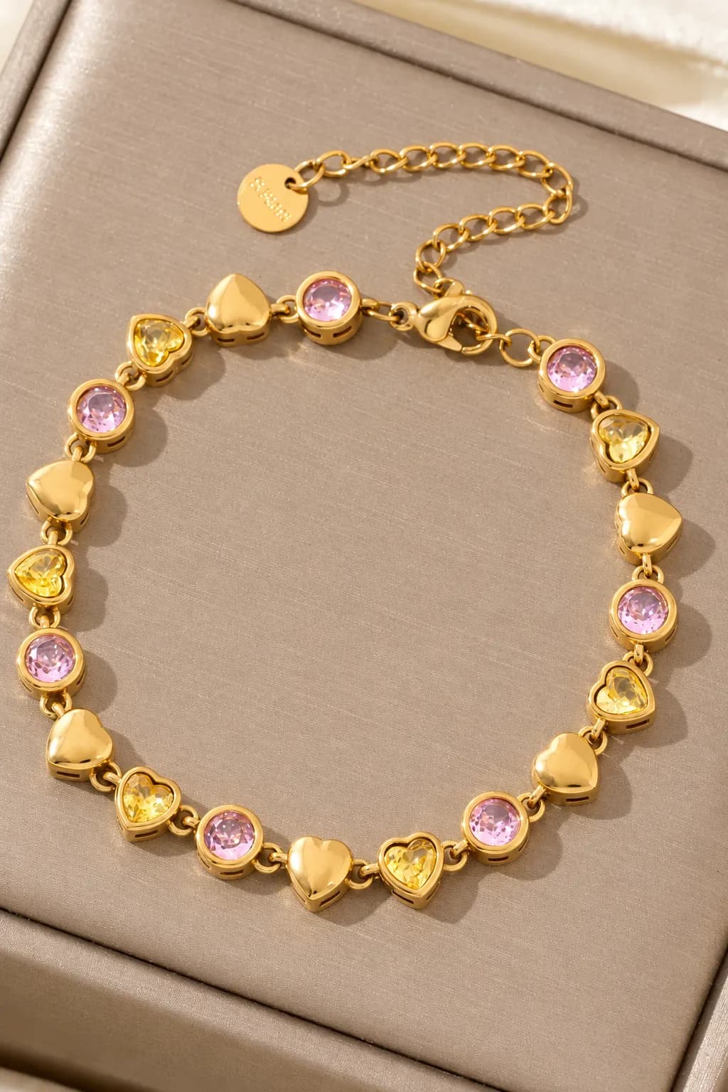 Gouden armband met hartjes en roze & gele steentjes